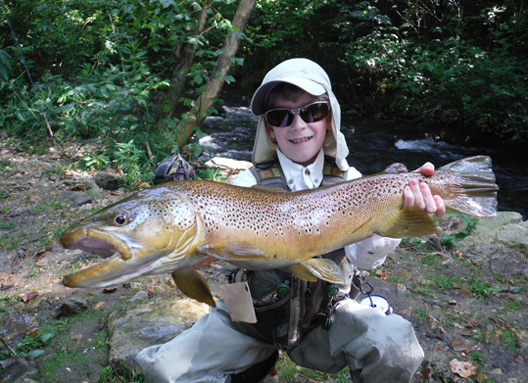 Tradd Little holding a 27" brown trout.